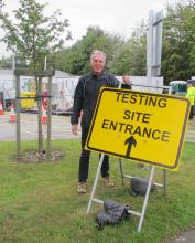 Council Leader standing beside a Covid test site sign
