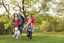 Family running with dog in park