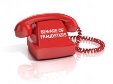 beware of fraudsters written on a telephone