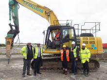 Andrew Jones (CPUK), Stuart Buckley (Public Sector Land, Homes England), Cllr Frank Allen & Nirmal Samrai CCDC in front of digger Andrew Jones (CPUK), Stuart Buckley (Public Sector Land, Homes England), Cllr Frank Allen & Nirmal Samrai CCDC in front of digger