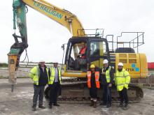 Andrew Jones (CPUK), Stuart Buckley (Public Sector Land, Homes England), Cllr Frank Allen & Nirmal Samrai CCDC in front of digger