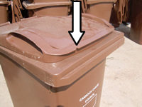 Brown bin with arrow showing where the notch is removed on the left hand side of the lid